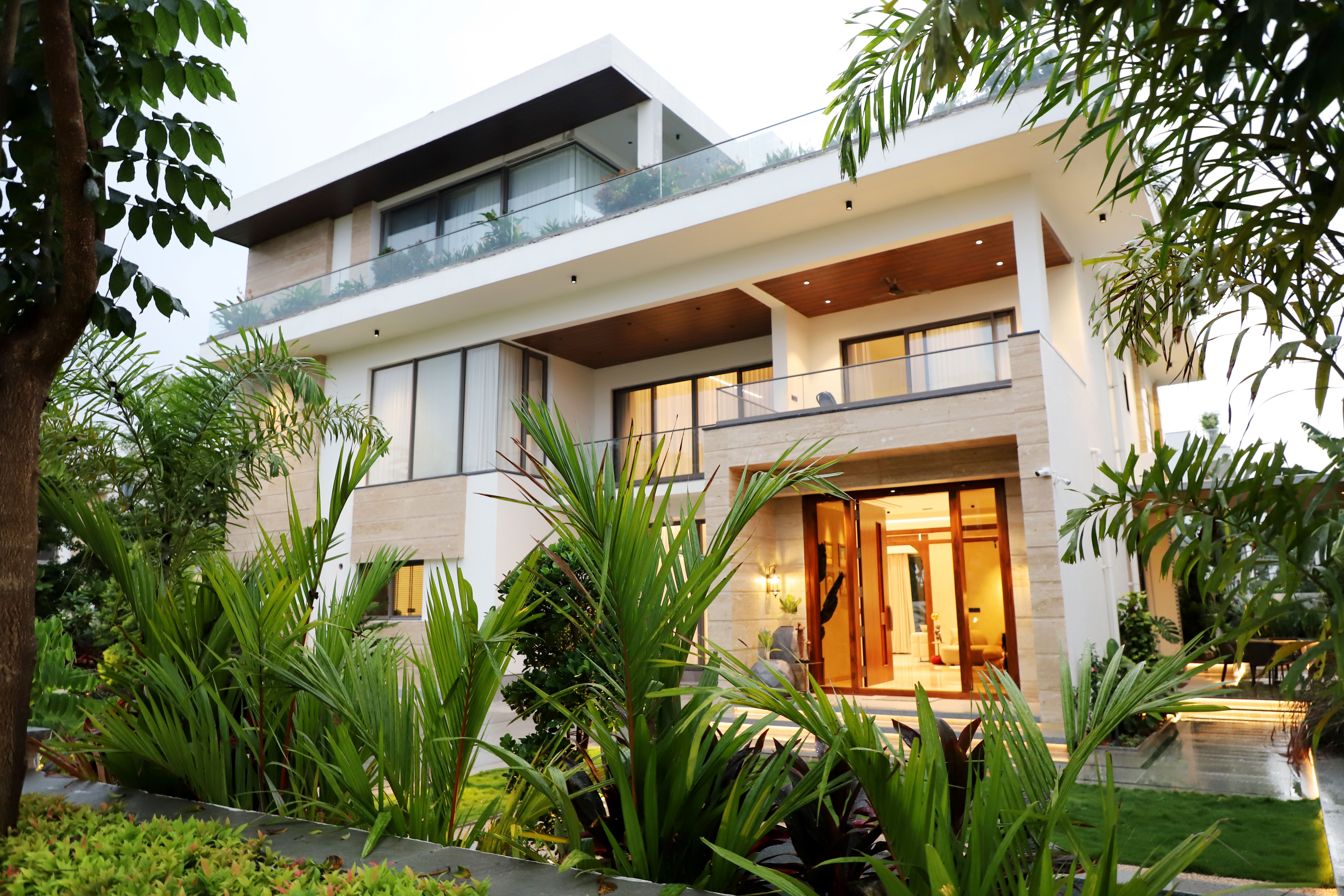 Luxury bungalow exterior with lush landscaping by Beyond Briks