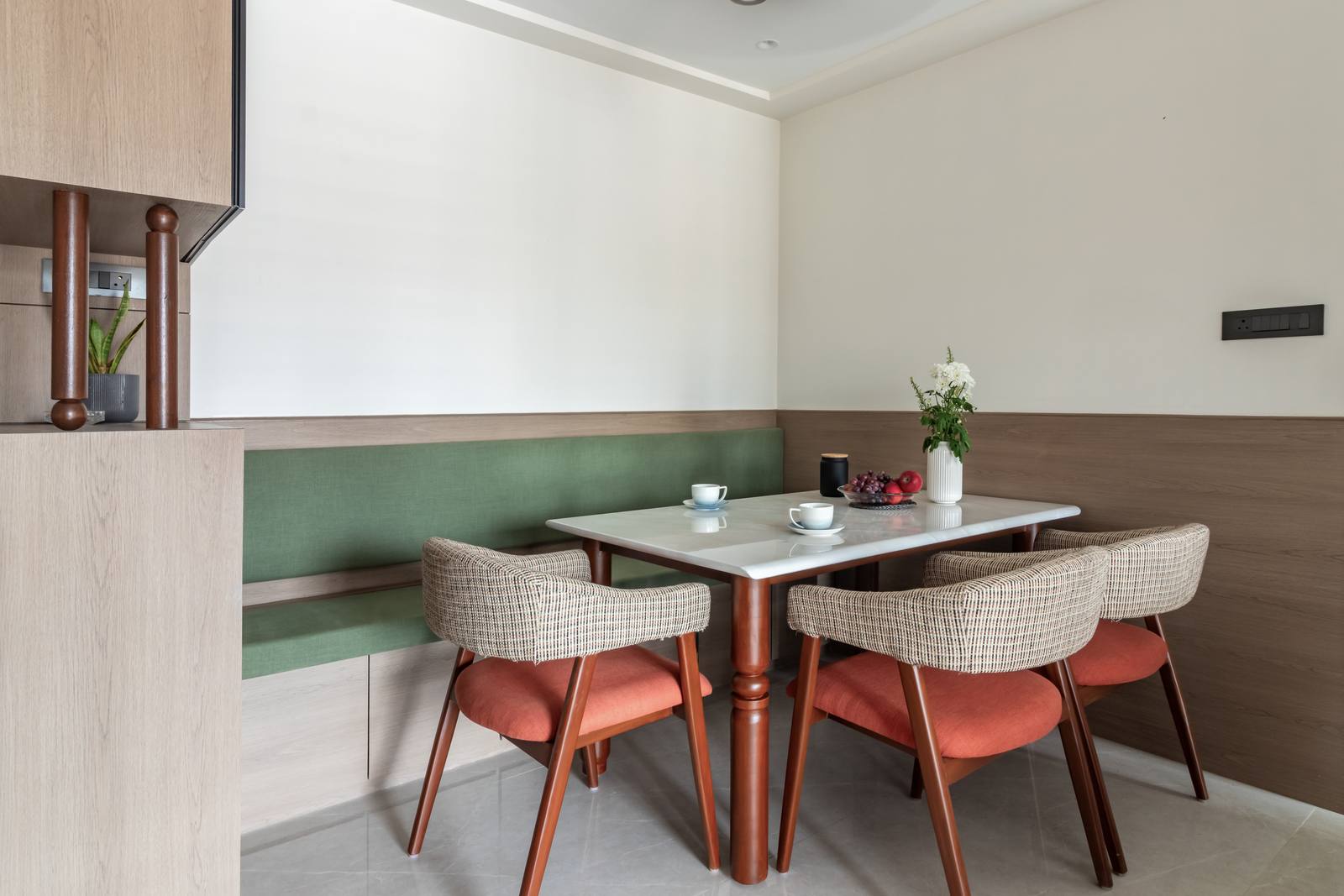 Cozy dining area with banquette seating and marble-top table designed by Beyond Briks Cozy dining area with banquette seating and marble-top table designed by Beyond Briks
