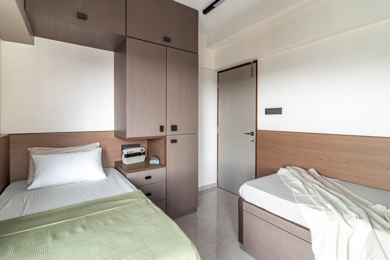 Children's twin bedroom with wood cabinetry and study nook by Beyond Briks