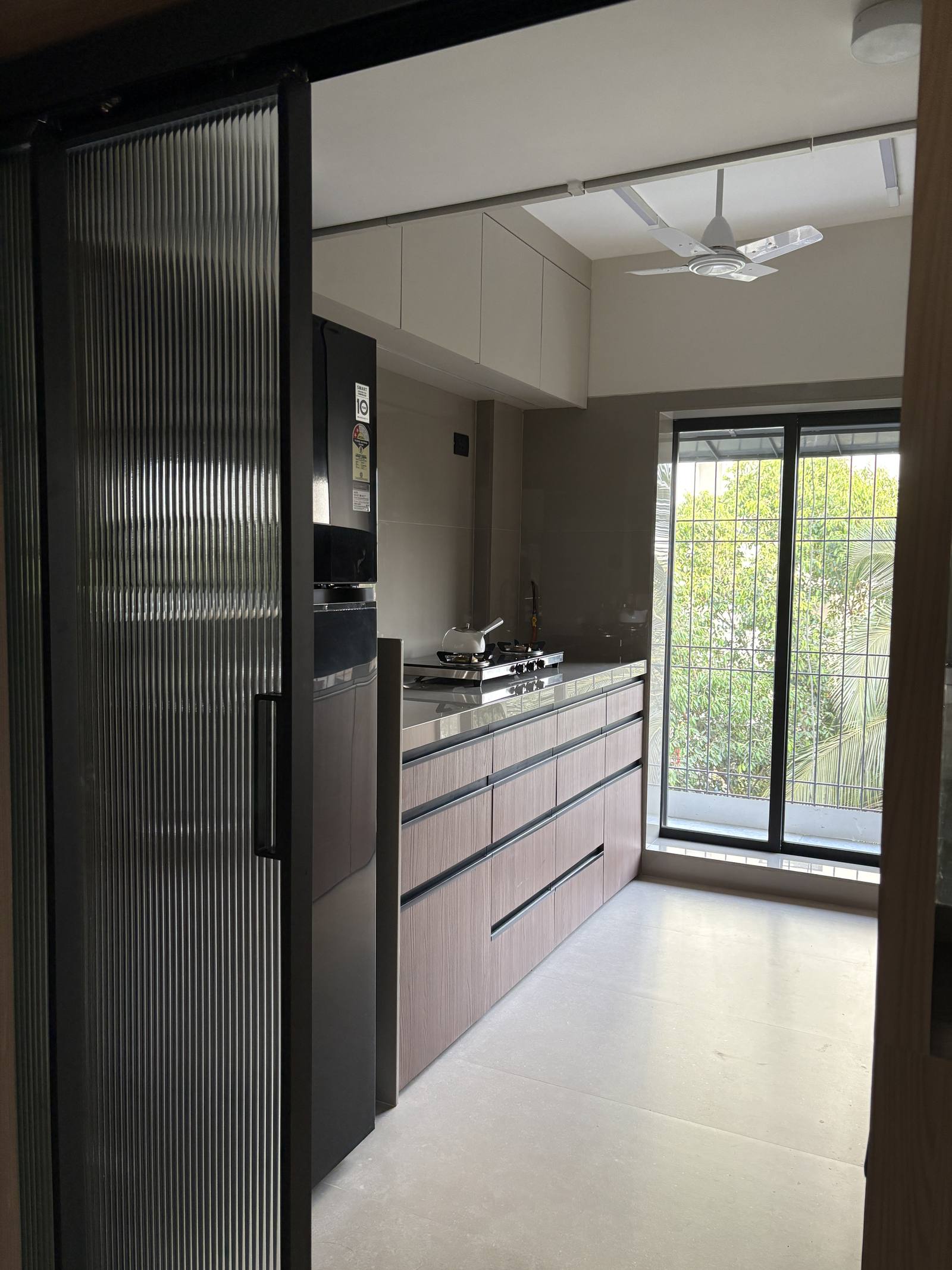 Modular kitchen entrance with fluted glass sliding door by Beyond Briks Modular kitchen entrance with fluted glass sliding door by Beyond Briks