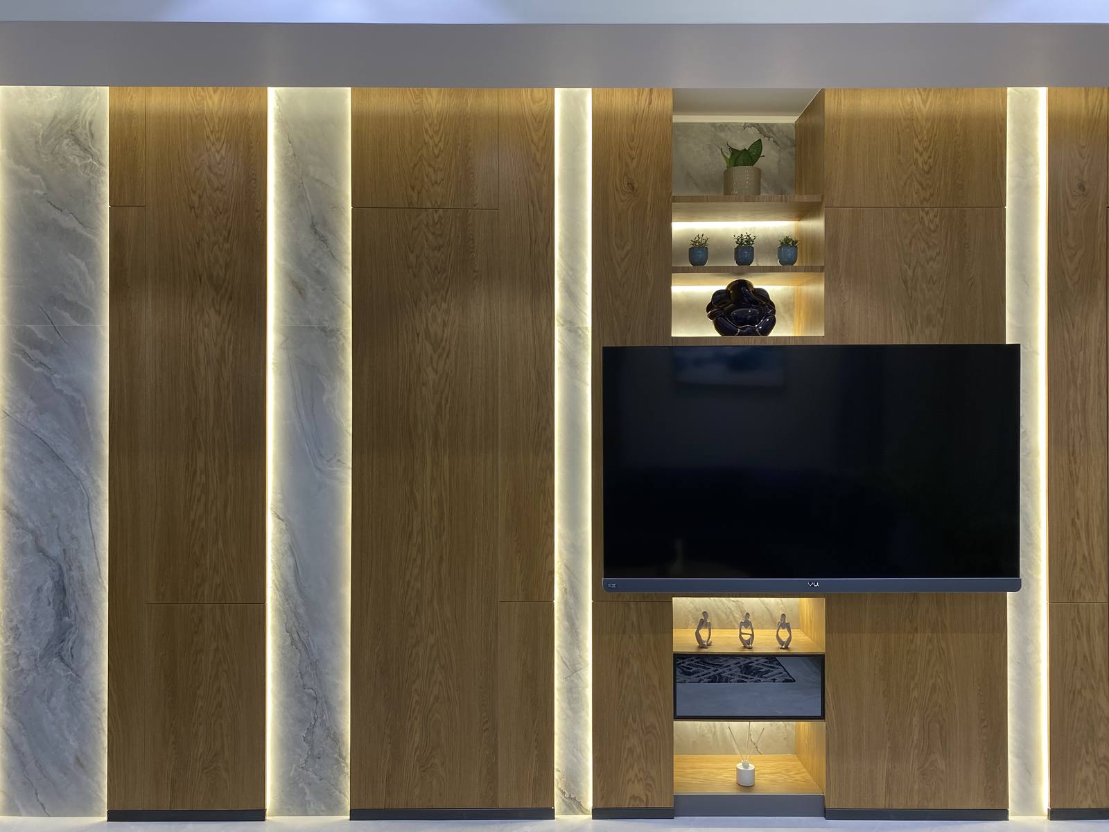 Marble-clad TV feature wall with backlit paneling by Beyond Briks Marble-clad TV feature wall with backlit paneling by Beyond Briks